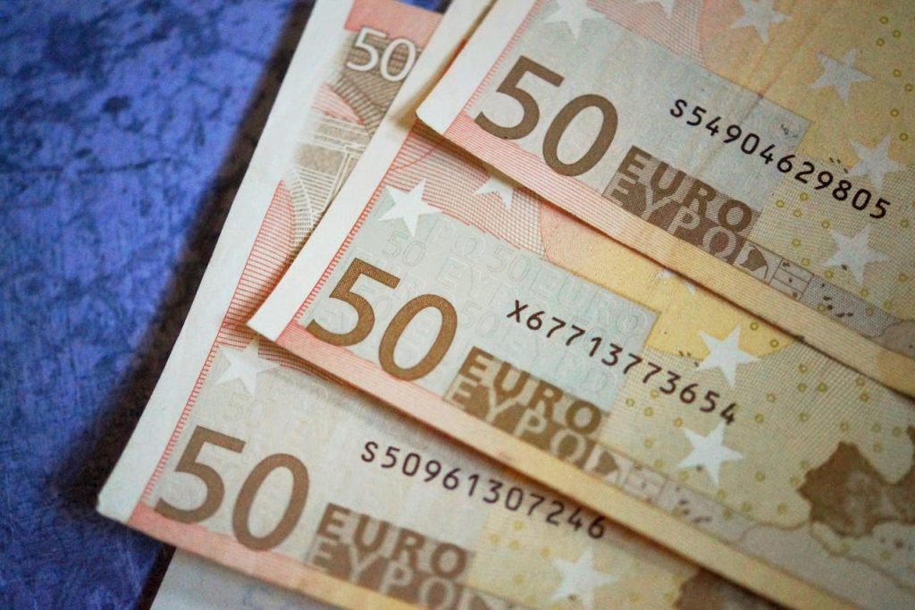 L'immagine è una fotografia di 3 banconote da 50 euro ognuna poggiate su un tavolo